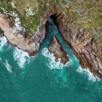 Foto aérea da Toca da Baleia, maior caverna marinha em extensão da Ilha (100 metros), situada no costão entre a Praia do Matadeiro e a Praia da Lagoinha do Leste, no Parque Natural Municipal da Lagoinha do Leste.